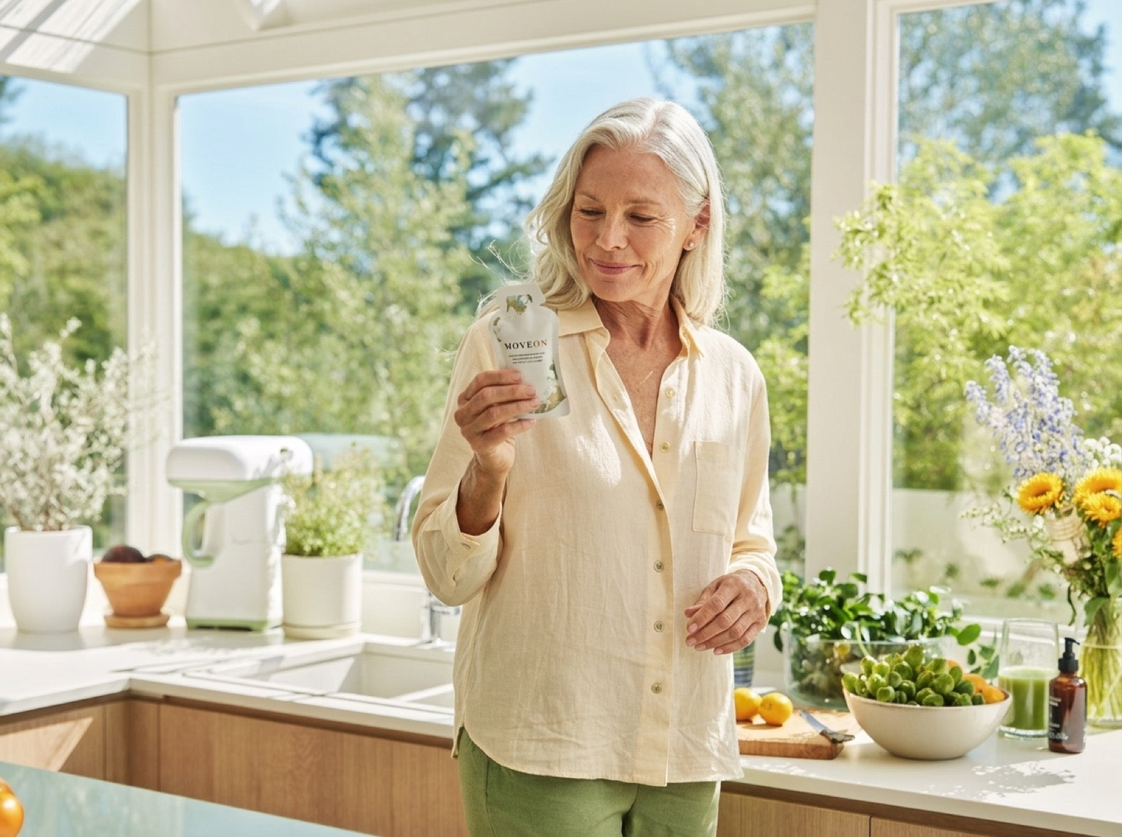 A radiant woman in her sixties laughing in a sun-filled kitchen